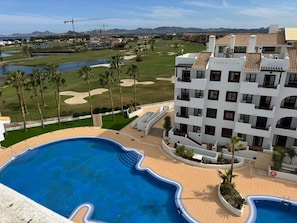 Ein Hotel mit Schwimmbad, Golfplatz und Bergblick.