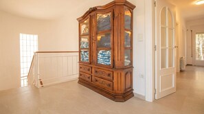 Ein geräumiges Zimmer mit einem Holzkasten, einer weißen Tür und einem weißen Geländer.