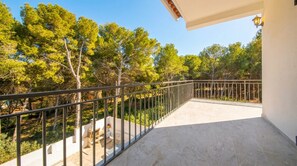 A balcony with a metal railing, a white wall, and a view of trees and greenery. - Villa Playa del Sur · 250m from the sea · 7 Suites · +19 guests  · Views 14 P (Capafonts)