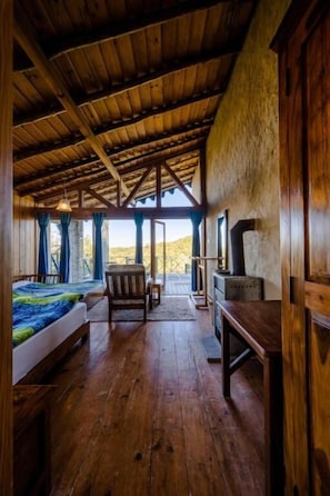Un interno in legno con un letto, una sedia, un tavolo e un camino.