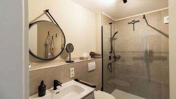 Ein modernes Badezimmer mit Waschbecken, Spiegel und Toilette.