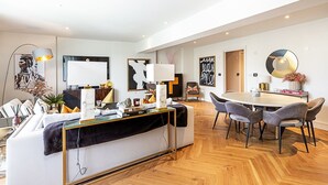 Een moderne woonkamer met een bank, salontafel en een eethoek.