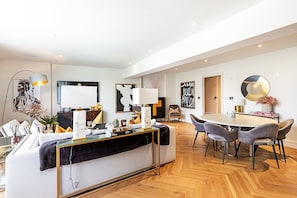 Ein modernes Wohnzimmer mit Sofa, Couchtisch und Essbereich.