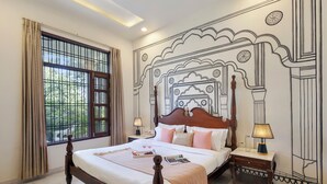 A bedroom with a large window, a bed with a wooden headboard, bedside lamps, and a decorative wall. - Alaya stays Haven Villa 3BHK with Pool (Bhankrota)