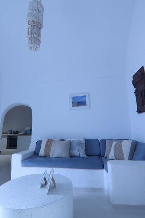 Ein modernes Wohnzimmer mit einem weißen Sofa, einem runden Couchtisch und einer Kristallleuchter.