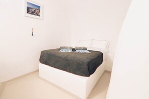 Ein Schlafzimmer mit einem Bett, einem gerahmten Bild an der Wand und einem kleinen dekorativen Gegenstand.