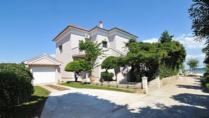 Ein zweistöckiges Haus mit Garage, umgeben von gepflegten Rasenflächen und Bäumen.