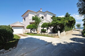 A two-story house with a garage, surrounded by well-maintained lawns and trees. - Amazing Place 4 Peaceful Holiday L (Poljana)