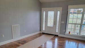 Une pièce spacieuse dotée d’un plancher en bois, d’un ventilateur de plafond et d’une grande fenêtre offrant une belle vue.