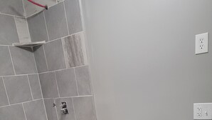 Une salle de bain avec des toilettes blanches, une baignoire et un lavabo doté d’un plan de travail en marbre.