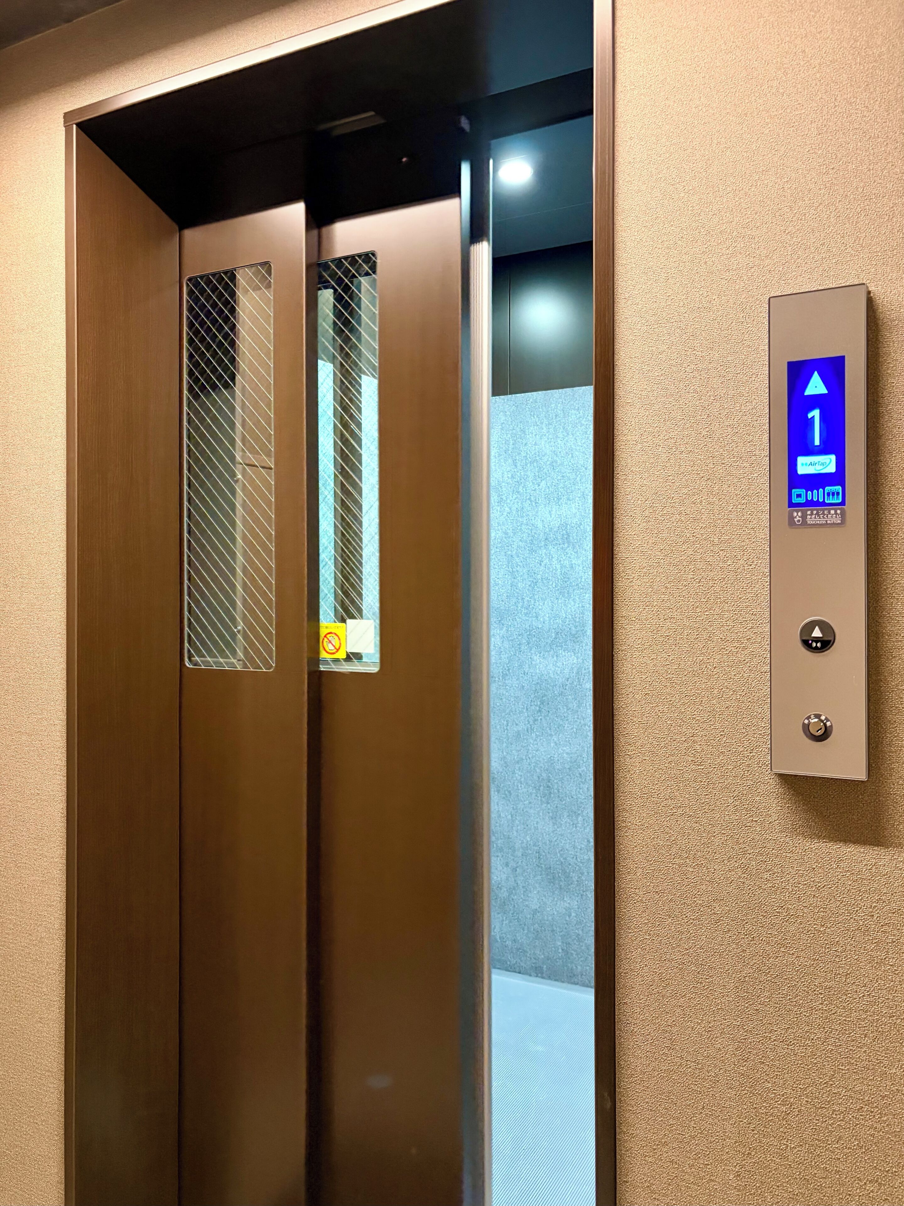 An elevator with a digital display indicating the floor number and a directional arrow.