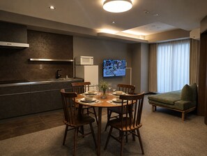 A modern kitchen with a dining area, a flat-screen TV, and a sofa. - KITAYAMA HOTEL ASAKUSA (Taito-ku)