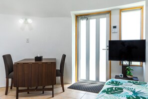 A room with a bed, a TV, a desk, and a chair. - URUMA DOME Jupiter 6 (Uruma)