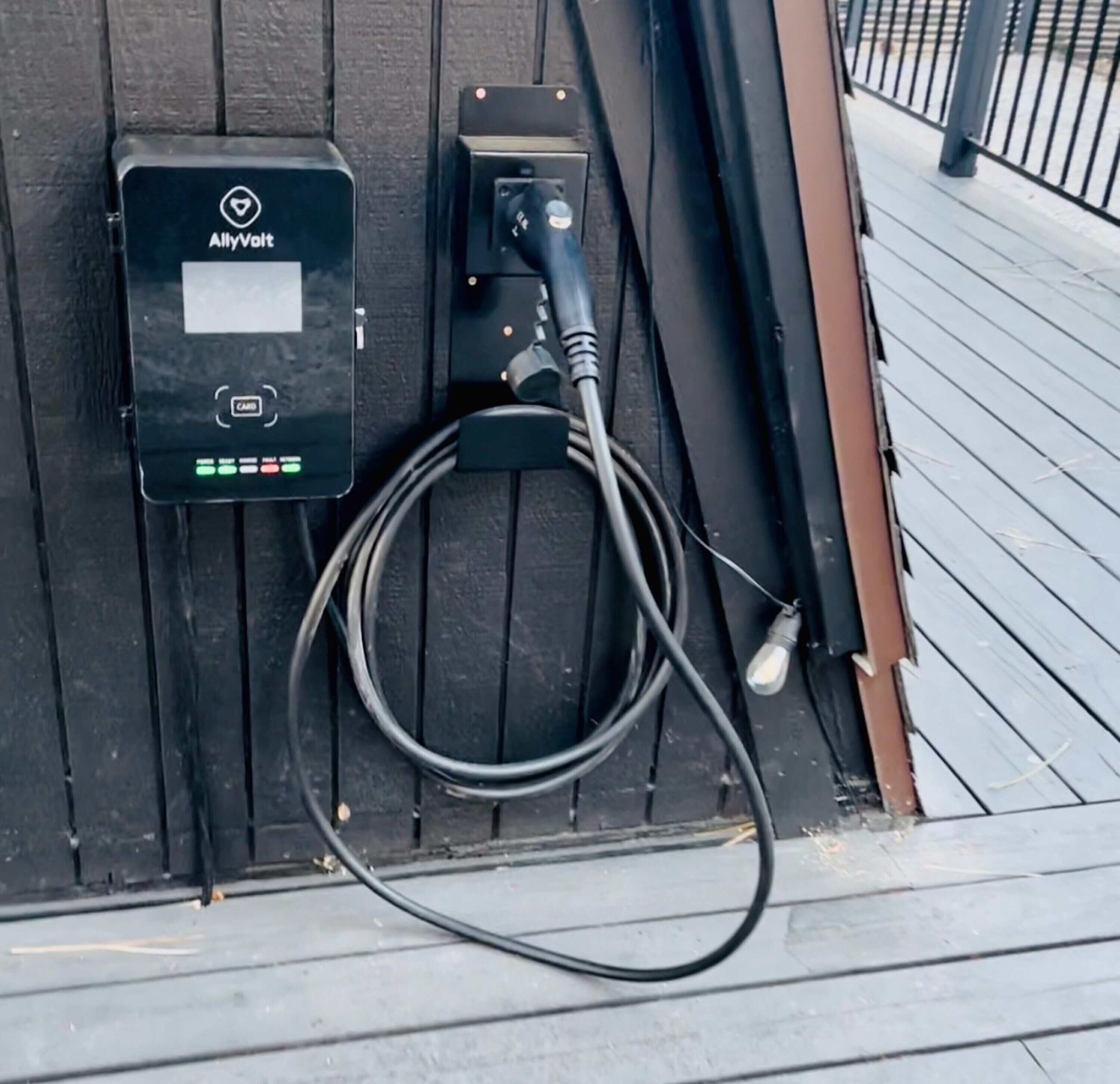 A black metal box labeled 'AllyVolt' with a cable connected to it.