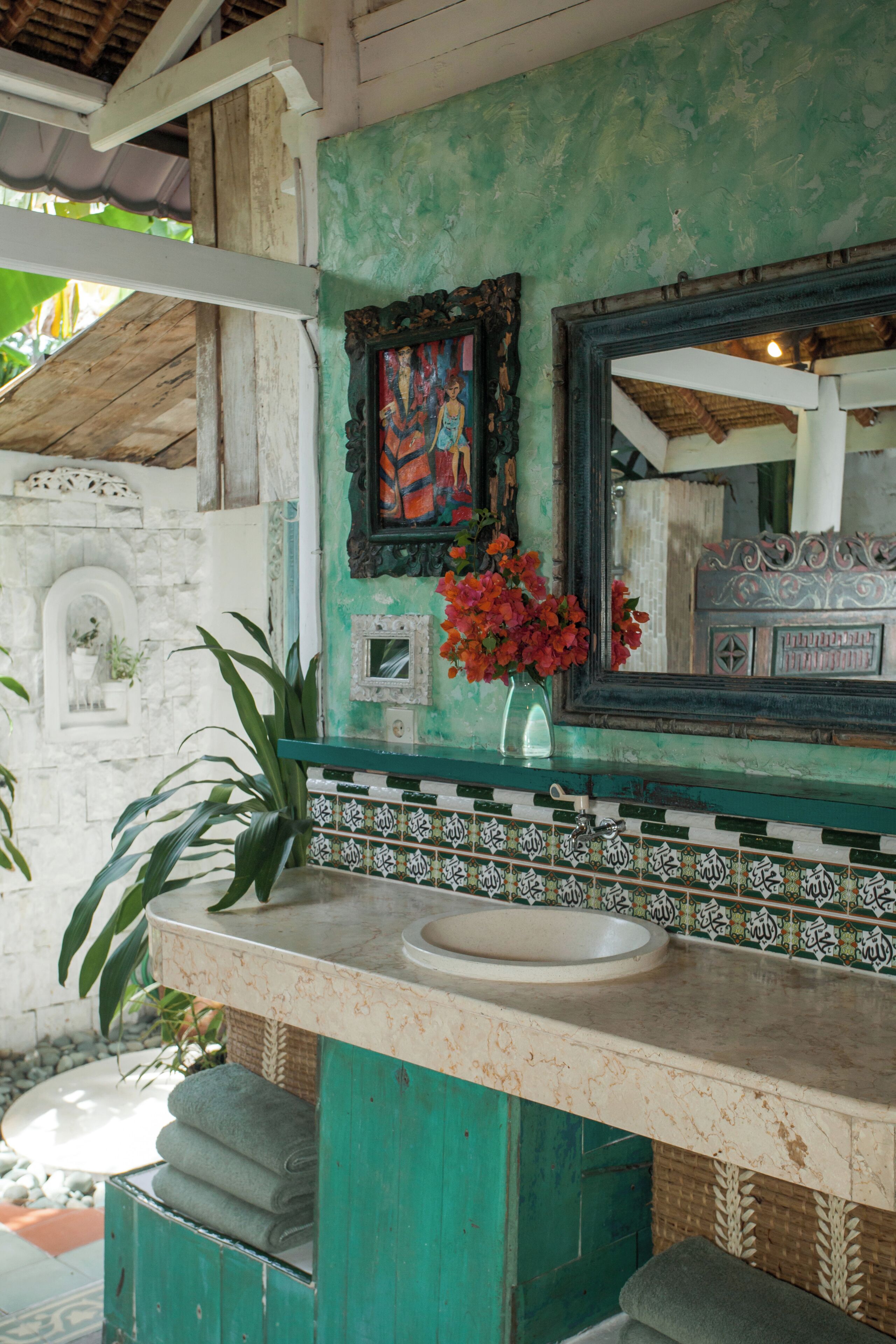 A bathroom with a sink, mirror, and decorative tiles.