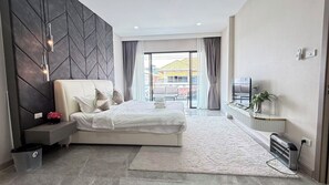 Une chambre d’hôtel moderne, équipée d’un lit, d’une table de chevet et offrant une vue sur l’extérieur.