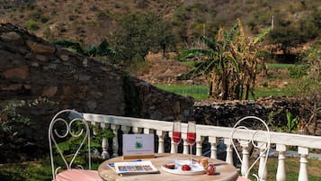 A table with a brochure, two glasses of red wine, and a plate with food.
