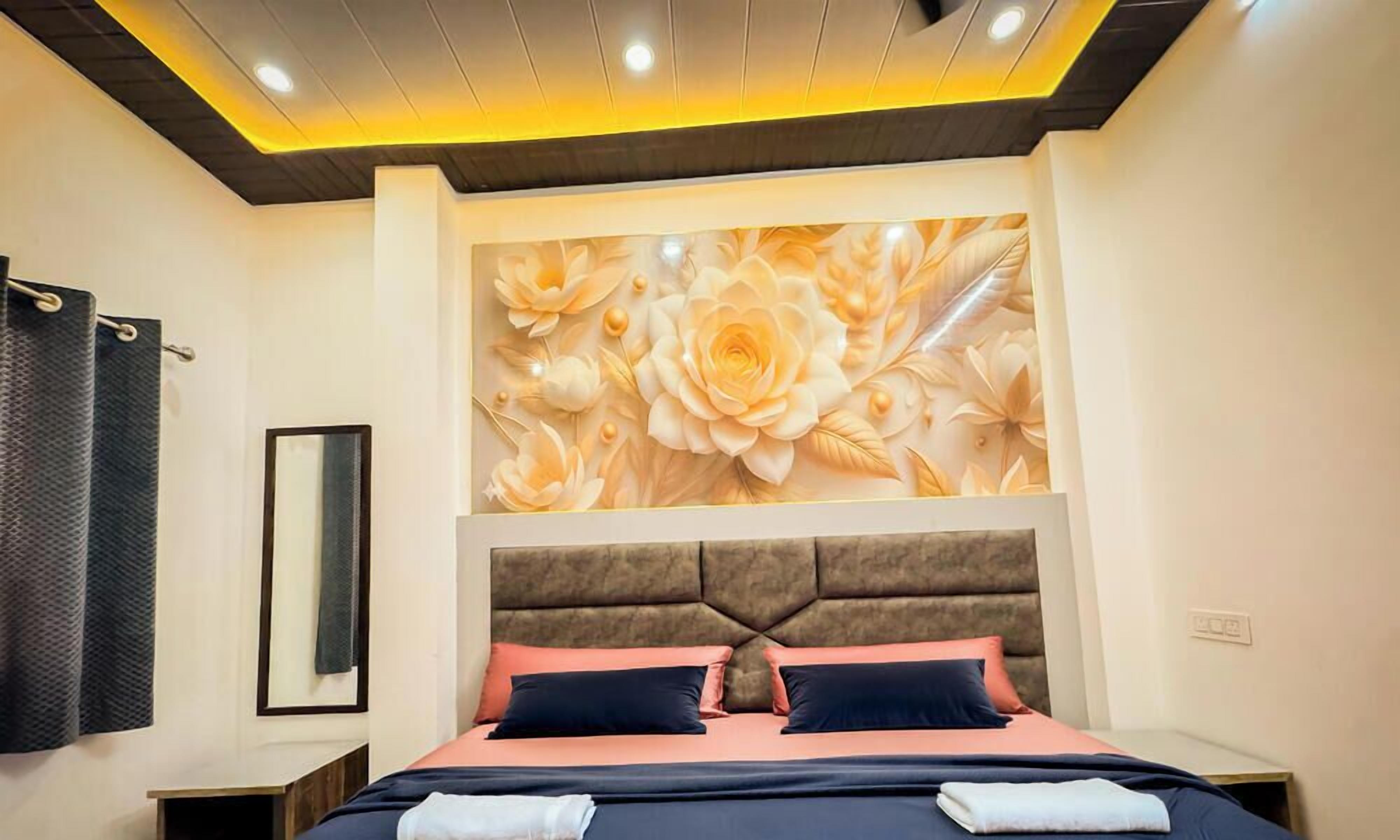 A bedroom with a large bed, a headboard with a floral mural, and a nightstand.