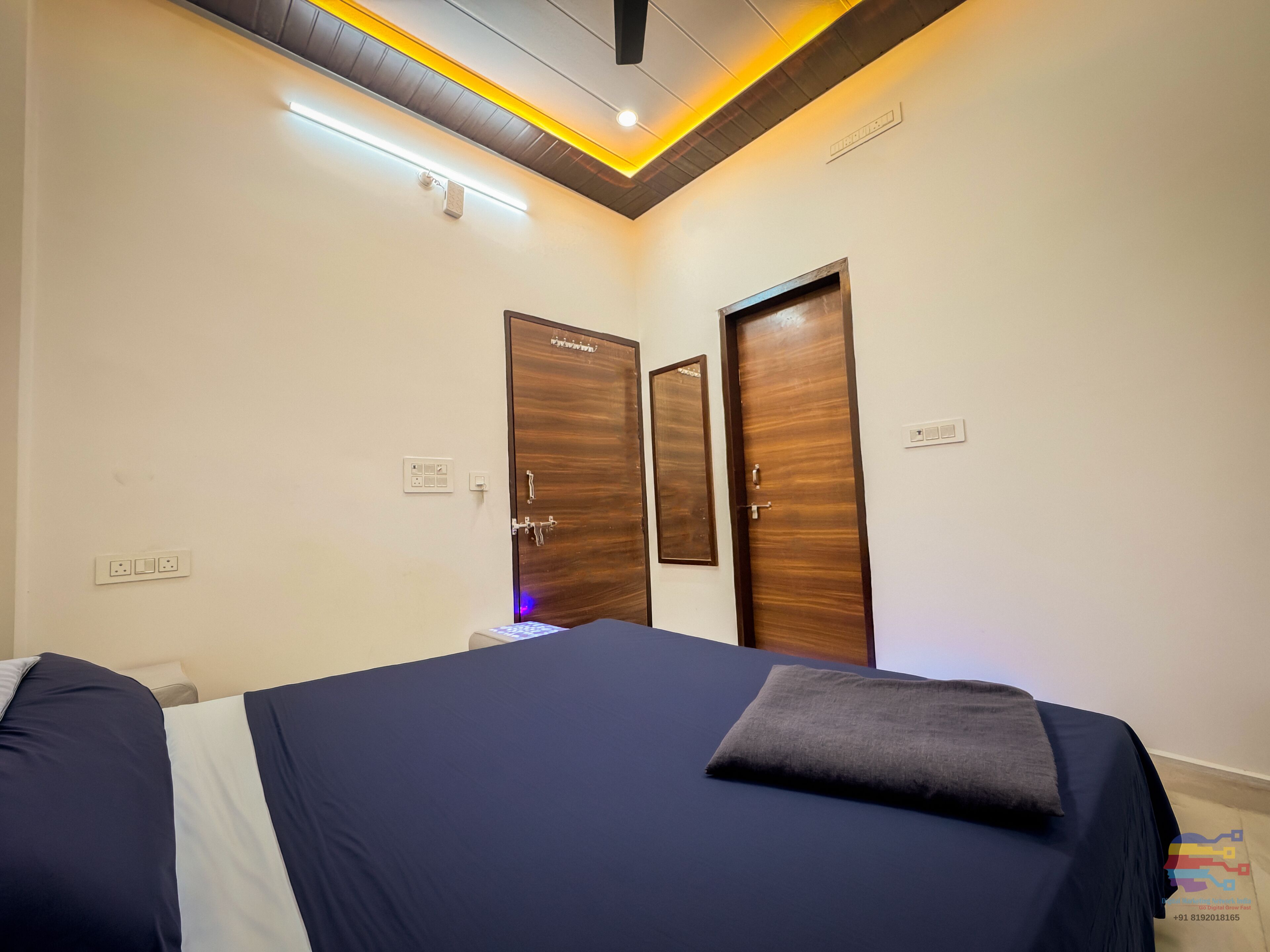 Une chambre à coucher avec un lit, deux portes et un luminaire au plafond.