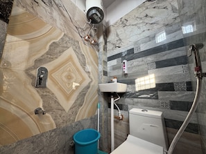A bathroom with marble walls, a sink, a toilet, and a shower. - Ganga Dham - Banke Bihari 200 Mtr (Vrindavan)