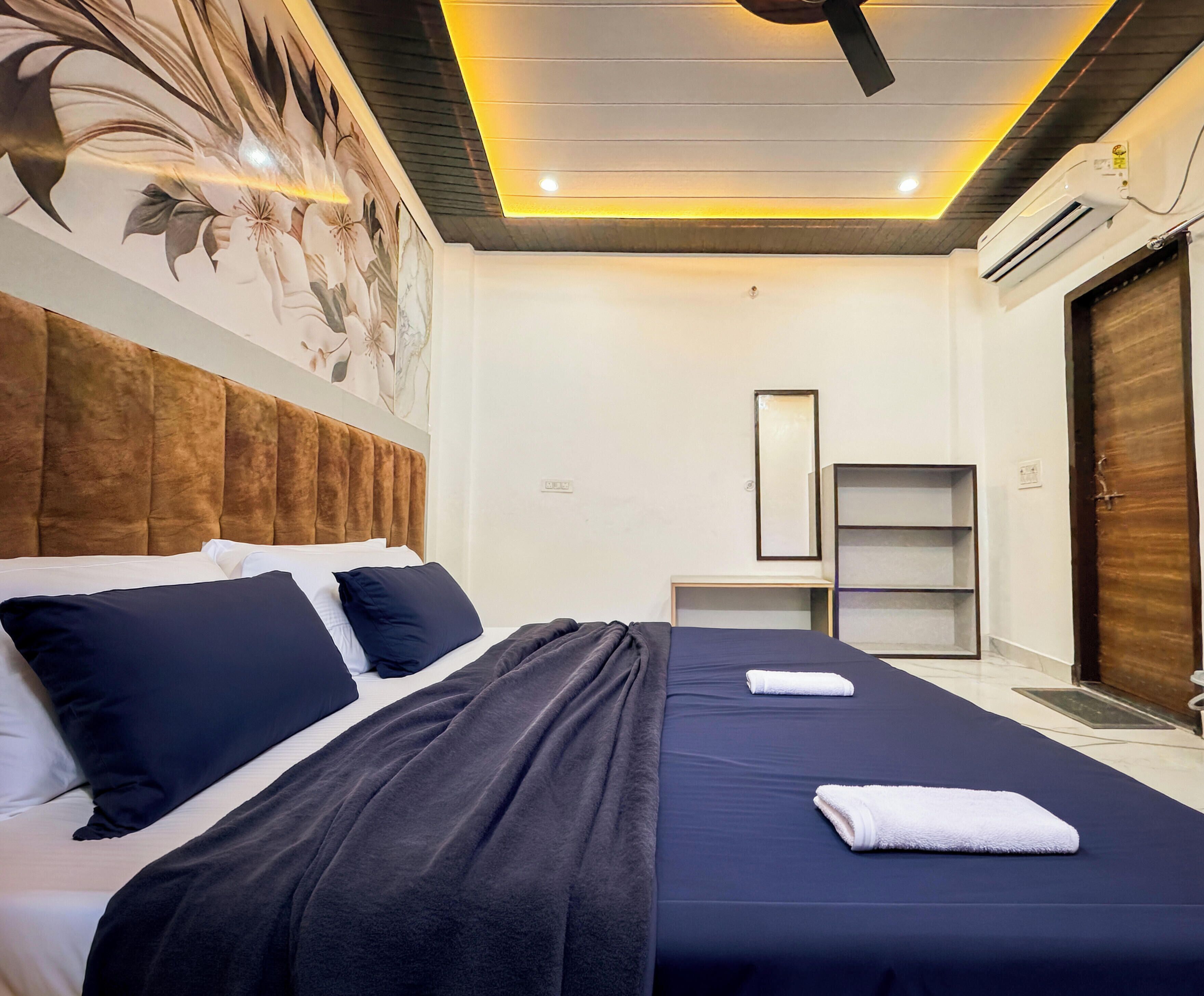 A hotel room with a bed, a bedside table, a wardrobe, and a ceiling fan.