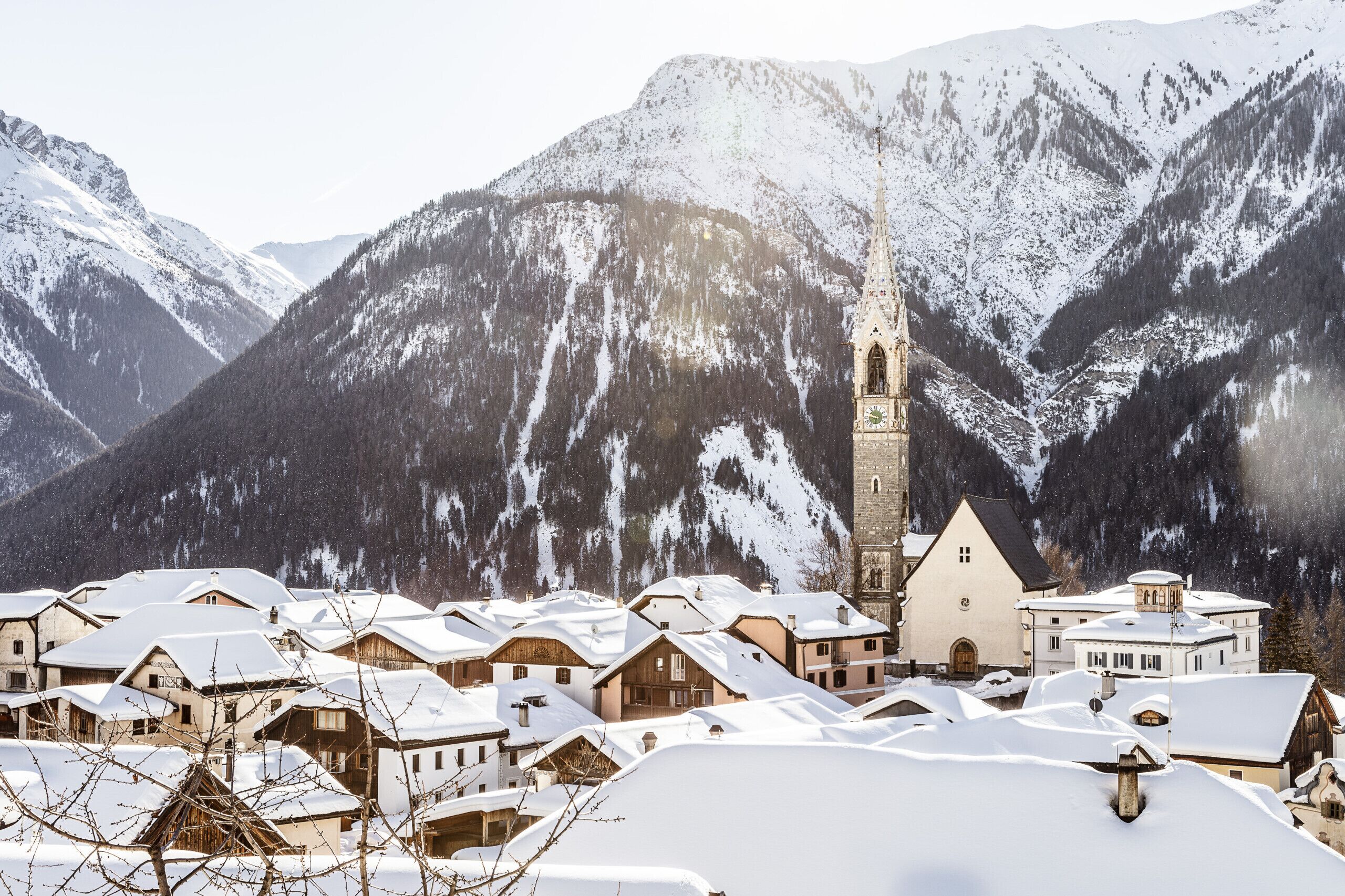 A snow-covered village with traditional buildings and a church.