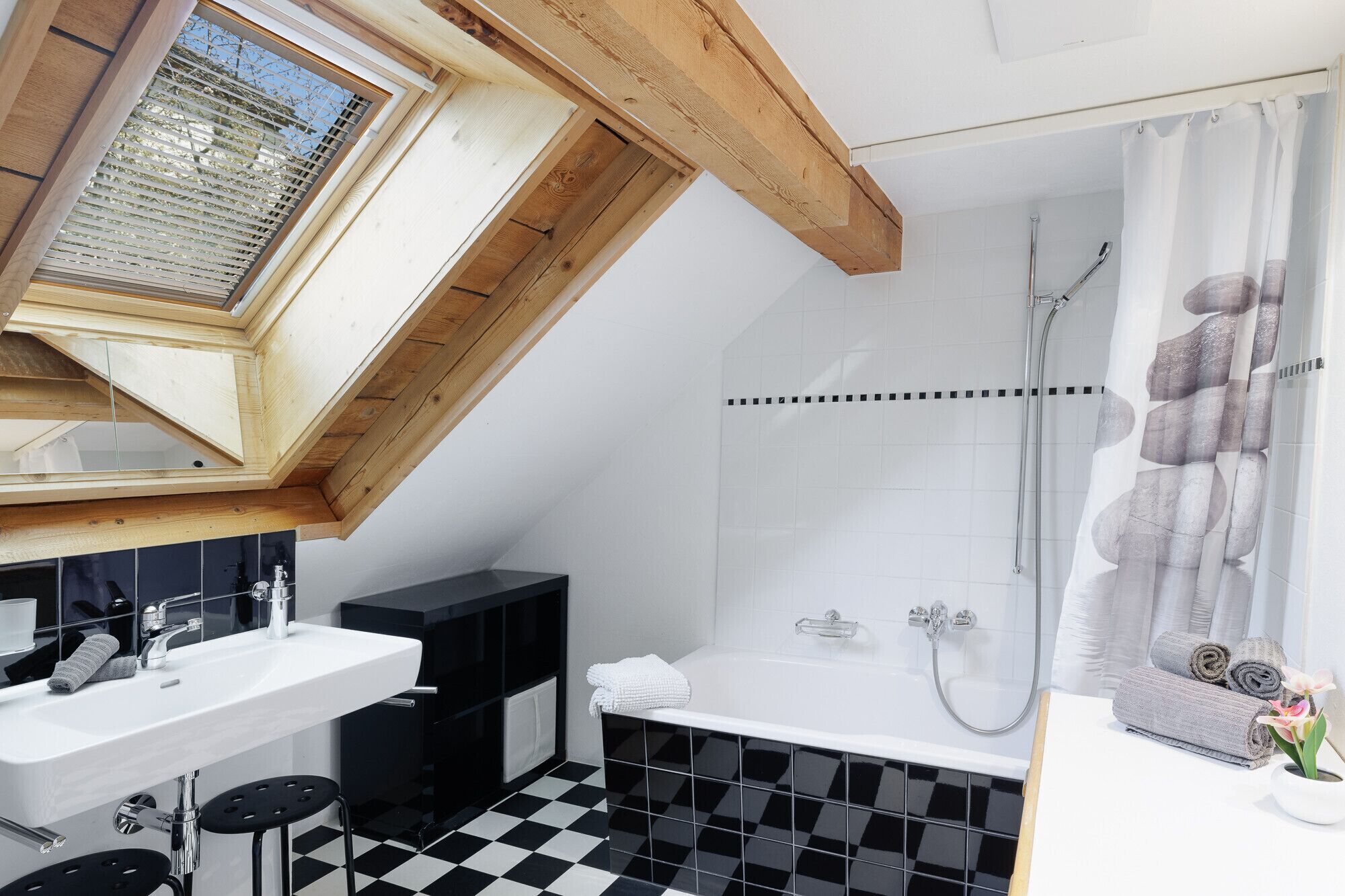 Een moderne badkamer met dakraam, een badkuip en een douche.