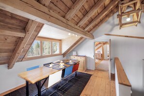 Ein Holzinterieur mit Essbereich, einer Küche und Blick ins Freie.