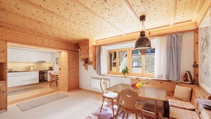 Un intérieur en bois comprenant une cuisine, un coin repas et une fenêtre avec des rideaux.