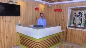 A reception desk with a flat-screen TV, a no smoking sign, and a framed artwork on the wall. - HOTEL BLUE ORCHID GROUP OF MR HOTELS (Udaipur)