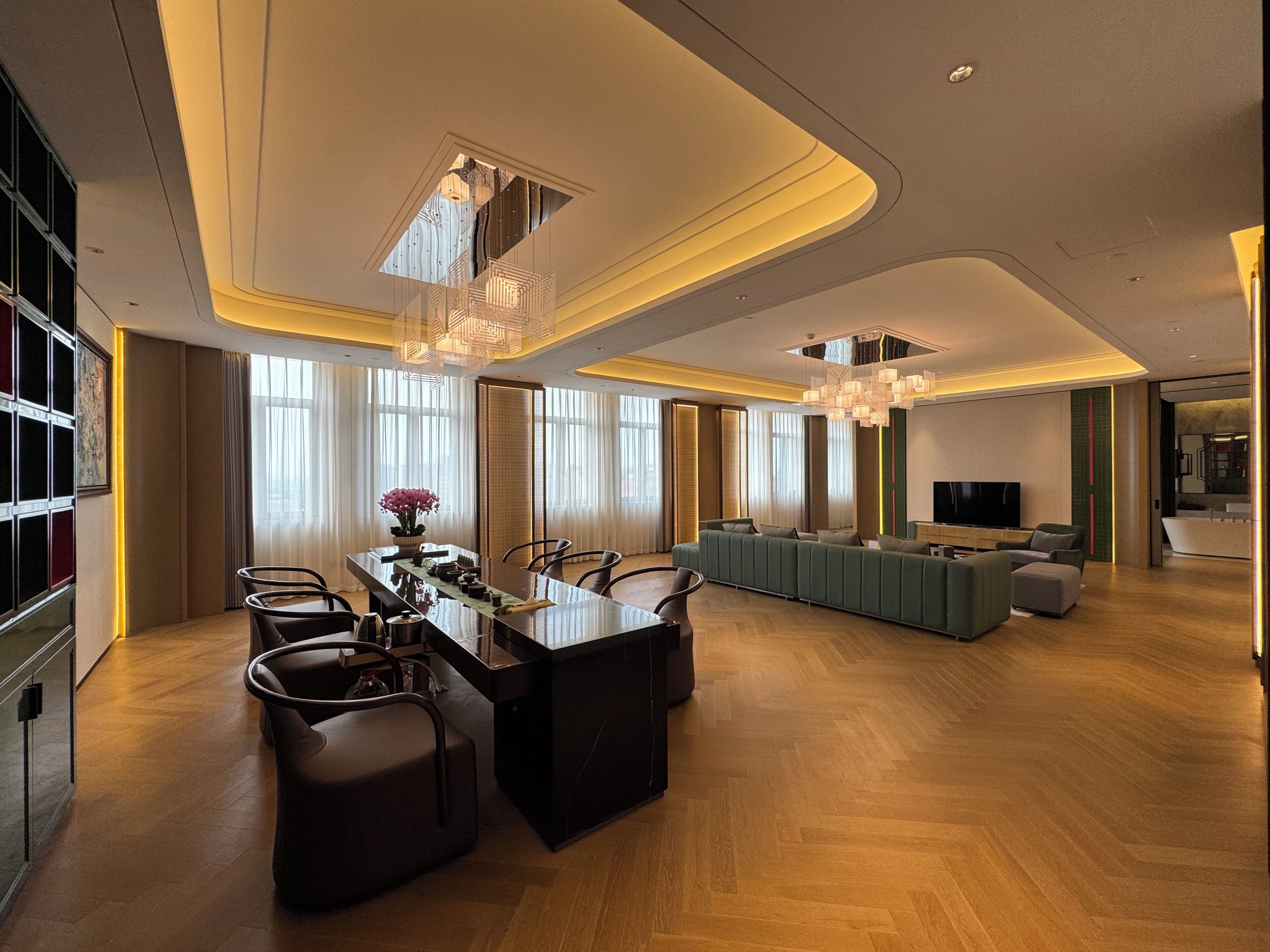 Una sala de estar moderna con comedor, ventanas amplias y un televisor de pantalla plana.