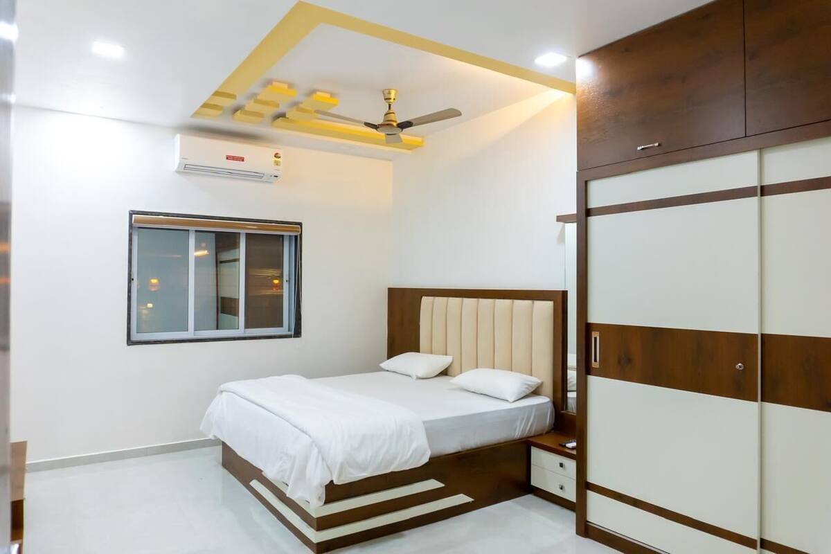 Un dormitorio con cama, armario, ventana y ventilador de techo.