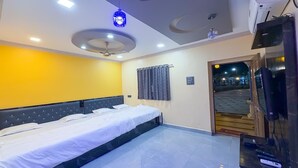 Habitación de hotel con una cama, un televisor y una puerta que da al exterior.