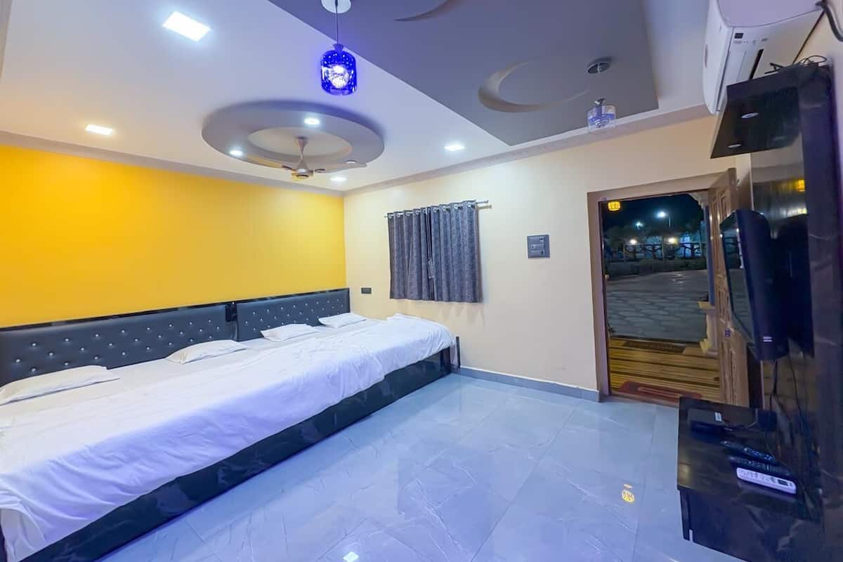 Habitación de hotel con una cama, un televisor y una puerta que da al exterior.