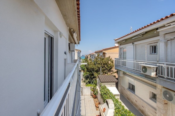 Ein Wohngebäude mit Balkon, Satellitenschüssel und kleinem Garten.