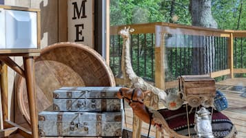 Een houten interieur met een 'WELCOME'-bord, een girafbeeld en oude koffers.