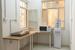 Eine Küche mit Mikrowelle, Wasserspender und einer Arbeitsplatte mit Herd.