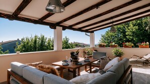 A covered outdoor seating area with a table set for dining, cushioned seating, and potted plants. - Istrian Villa Beatrice Near Pula (Vodnjan)