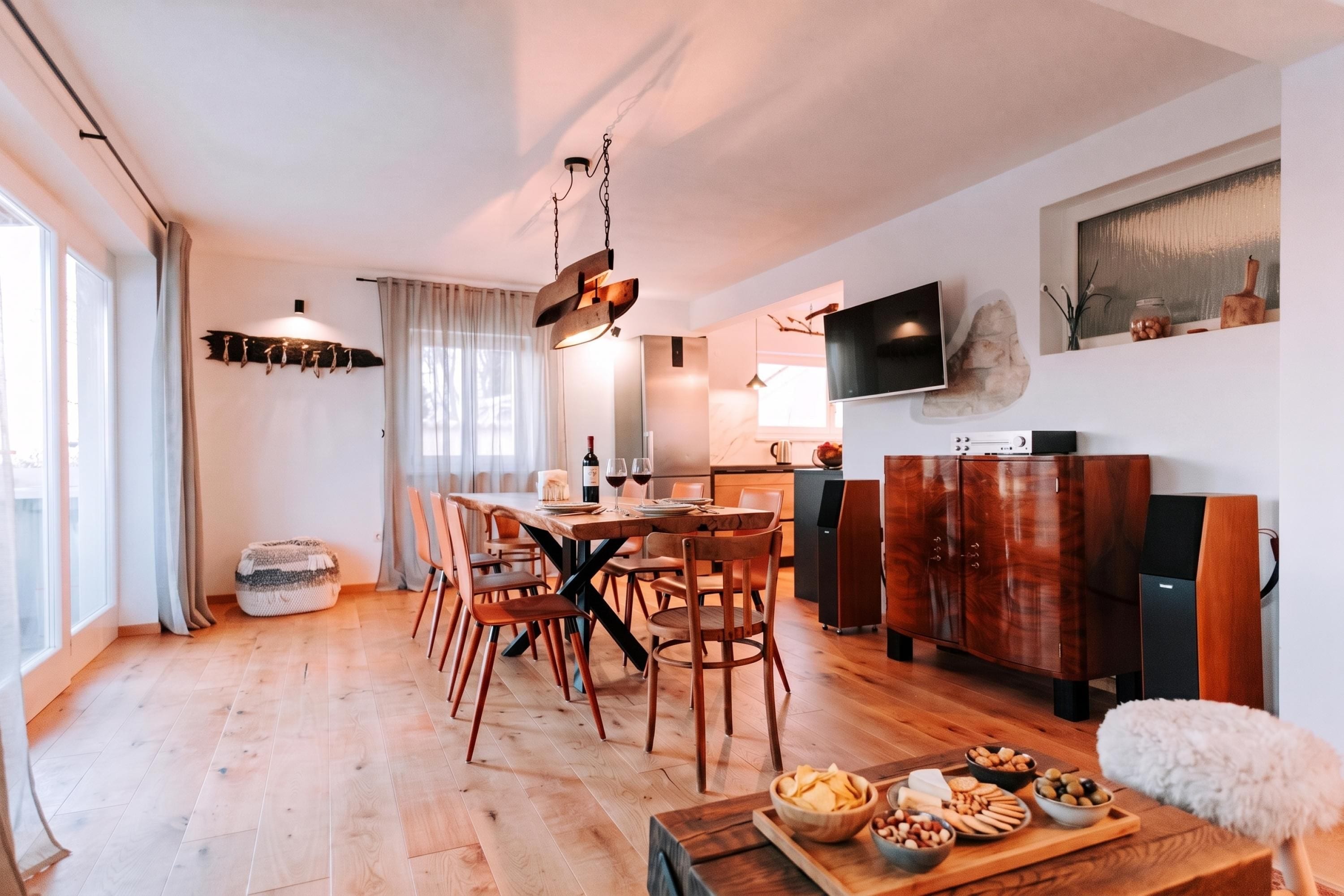 Un espace repas moderne avec une table en bois, des chaises et un buffet garni de collations.