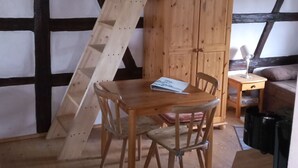 A room with a wooden table, chairs, a cabinet, and a ladder. - Vacation on the farm (2P) (Hohenleuben)
