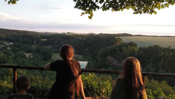 A view from a balcony overlooking a forested valley with a distant body of water. - Vacation on the farm (2P) (Hohenleuben)