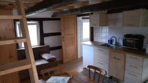 A kitchen with wooden cabinets, a microwave, and a sink. - Vacation on the farm (2P) (Hohenleuben)