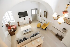 A modern living room with a sofa, chairs, a TV, and a unique chandelier. - Christy’s Three-Level Villa in Mykonos Town (Mykonos)