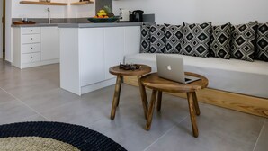 Et moderne køkken med hvide skabe, en central ø og en hængende lampe.