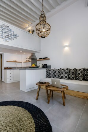 Une cuisine moderne avec des meubles blancs, un îlot central et un luminaire suspendu.
