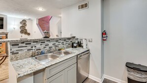 A kitchen with a granite countertop, stainless steel sink, and a dishwasher. - 3BR Townhome Near Downtown Decatur (Decatur)