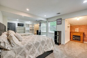 Un dormitorio con cama, chimenea, espejo y armario.