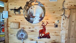 A wooden wall with a circular mirror, a deer sculpture, and a wolf sculpture. - Cortez RV Resort (Cortez)