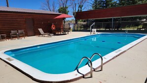 A rectangular swimming pool with a metal ladder, surrounded by a concrete deck. - Cortez RV Resort (Cortez)
