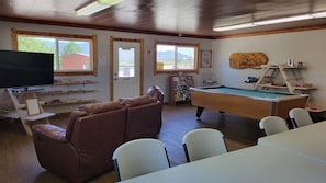 A pool table, a television, a pool table, a couch, and a table with chairs. - Cortez RV Resort (Cortez)